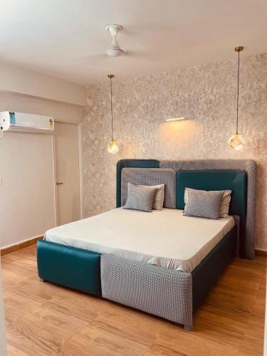 a bed in a room with a blue bed frame at HomeyStays 2BHK Lakeside walk in Rāi