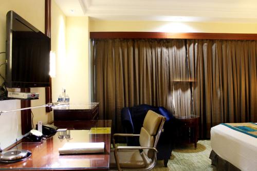 a hotel room with a desk and a bed at SkyCity Hotel Gurgaon in Gurgaon
