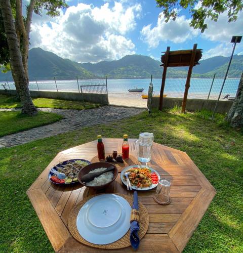 a table with plates of food on it with a view of the beach at Belongas Bay Lodge LOMBOK in Blongas