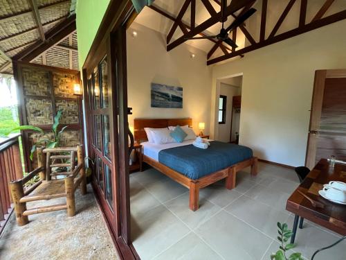 a bedroom with a bed and a chair in a room at Surfista Villa Siargao in General Luna