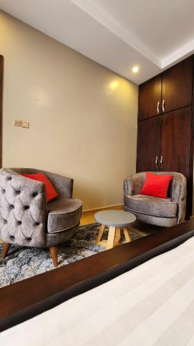 two chairs and a table in a living room at Golden Castle Hotel Hoima in Hoima