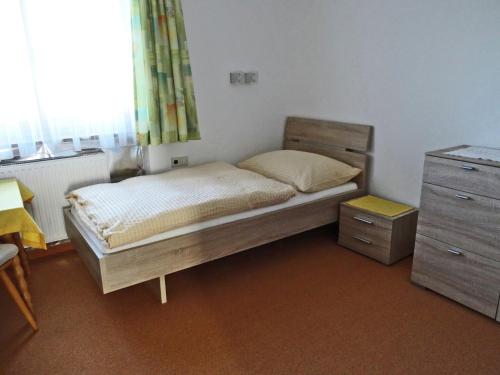 a bedroom with a bed and a dresser and a window at Apartment with balcony in Hart im Zillertaler in Fügen