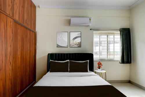 a bedroom with a large bed and a window at Super Hotel O Shamshabad Airport Complex Formerly Urban Sleep in Shamshabad