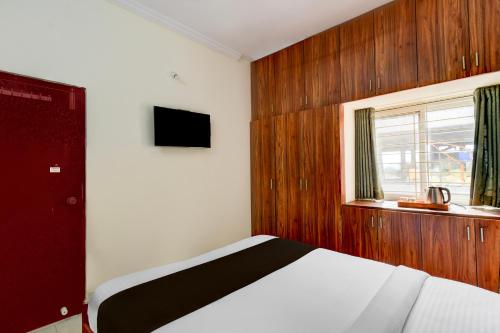 a bedroom with a bed and a window at Super Hotel O Shamshabad Airport Complex Formerly Urban Sleep in Shamshabad
