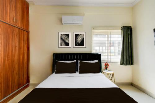 a bedroom with a black and white bed and a window at Super Hotel O Shamshabad Airport Complex Formerly Urban Sleep in Shamshabad
