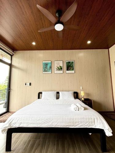 a bedroom with a bed with a ceiling fan at Horizon Homestay in Phong Nha