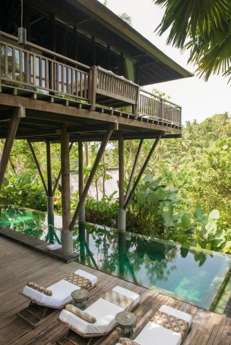 a resort with a deck and a swimming pool at Komaneka at Bisma Ubud in Ubud