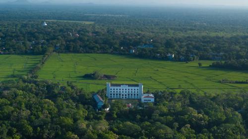 an aerial view of a white building in a field at Kynrock Hotels & Resorts Kataragama in Kataragama