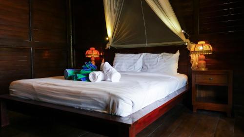 a bedroom with a bed with two towels on it at Turtle Garden Hotel in Gili Islands