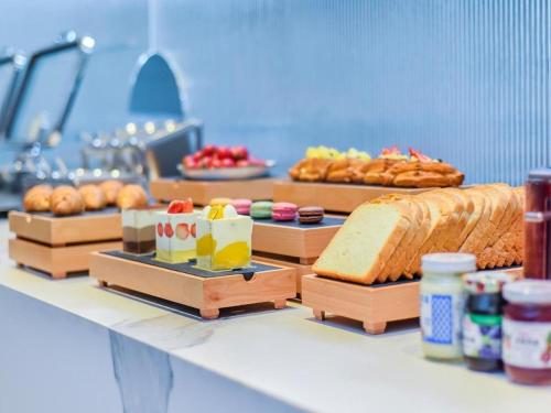 a table with various types of bread and pastries at Borrman Hotel Chongqing Bishan Central Street in Chongqing