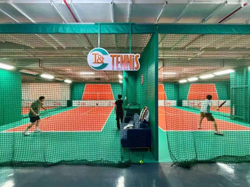 three people playing tennis on a tennis court at Shanghai T Plus Hotel Residence in Shanghai