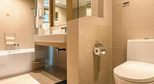 a bathroom with a white toilet and a sink at Xiamen Jingmin Central Hotel in Xiamen