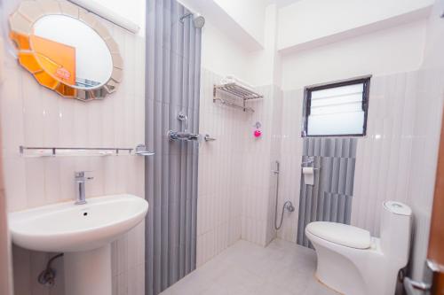 een badkamer met een wastafel, een toilet en een spiegel bij Hotel Romantica in Pokhara