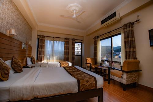 een hotelkamer met twee bedden en een raam bij Hotel Romantica in Pokhara