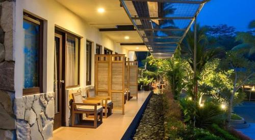 a porch of a house with chairs and a balcony at Sambi Resort, Spa & Resto in Yogyakarta