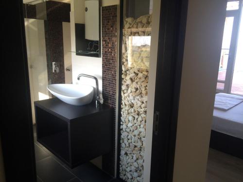 baño con lavabo y espejo en una habitación en Vila Brandusa, en Eforie Nord