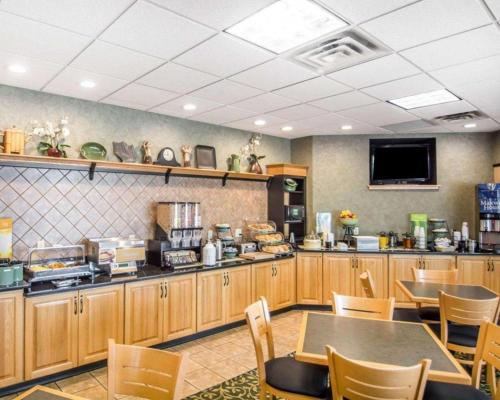 a restaurant with a table and chairs and a television at Quality Inn in Geneseo