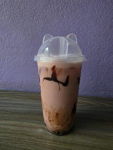 a drink in a plastic cup sitting on a table at Twins Cafe and Guest House in Rāmechhāp