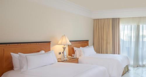 a hotel room with two beds and a window at Swissôtel Sharm El Sheikh - Ultra All Inclusive Collection in Sharm El Sheikh