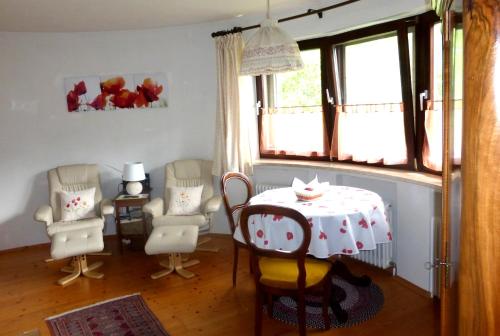 a dining room with a table and chairs and windows at Ferienwohnung Monika in Bad Ischl