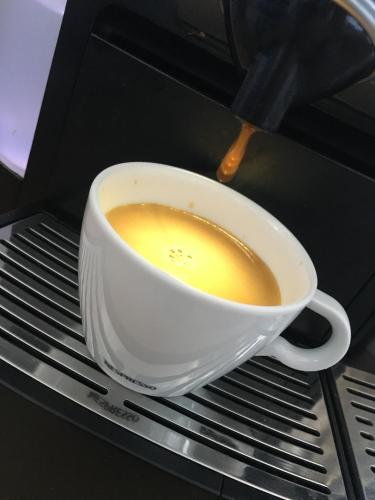 a cup of coffee is being brewed in a microwave at Poseidonio Hotel in Tinos Town