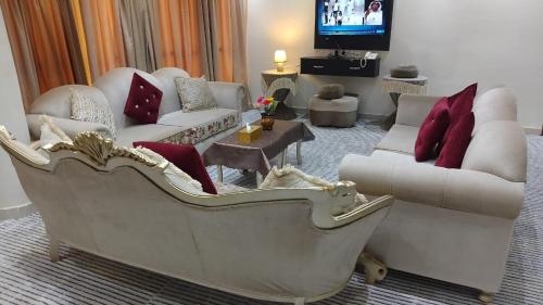 a living room with a large couch and couches at عرعر Desert Rose Hotel in Arar