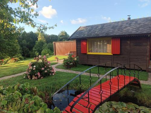 a house with a red bench in a yard at Viesu māja"Ordziņas" in Pāvilosta