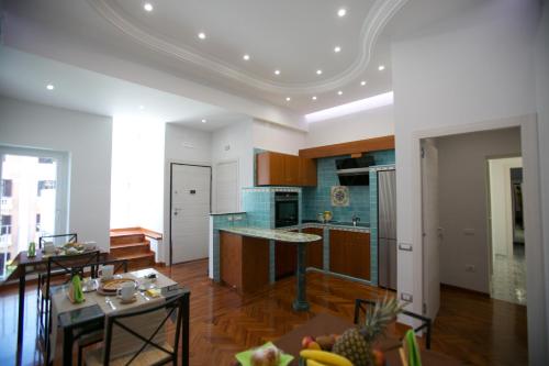 Una cocina y una sala de estar con una mesa y un mostrador. en B&B Divina Salerno, en Salerno