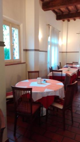 a dining room with two tables with red and white table cloth at Corte Degli Estensi in Formigine