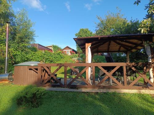a wooden gazebo in a yard with grass at Viesu māja"Ordziņas" in Pāvilosta