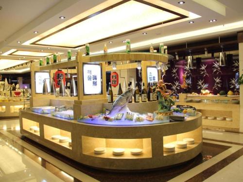 a lobby with a counter with a fish in the middle at Yanji Yanbian International Hotel in Yanji