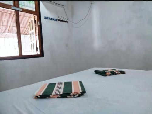 two napkins sitting on top of a bed with a window at Mango garden villa in Pottuvil