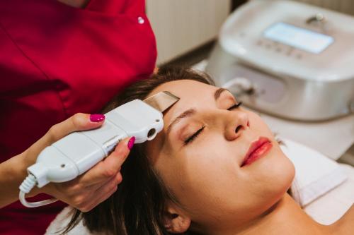 a woman getting her face examined by a dentist at Hotel Radocza Park Business in Radocza