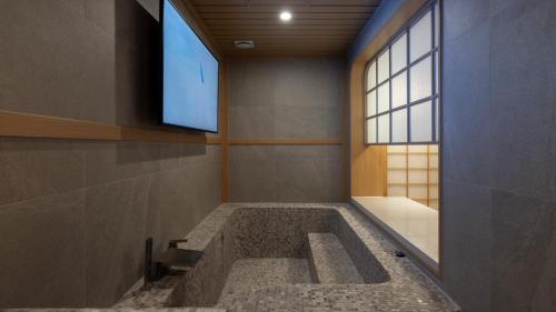 a bathroom with a tub with a window and a television at Stay Passport Airplane Guri in Guri