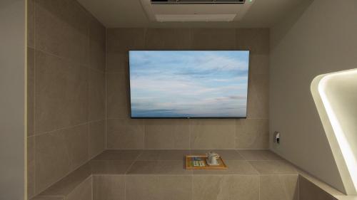 a bathroom with a flat screen tv on the wall at Stay Passport Airplane Guri in Guri