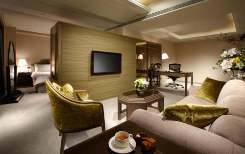 
a living room filled with furniture and a tv at The Landis Taipei in Taipei
