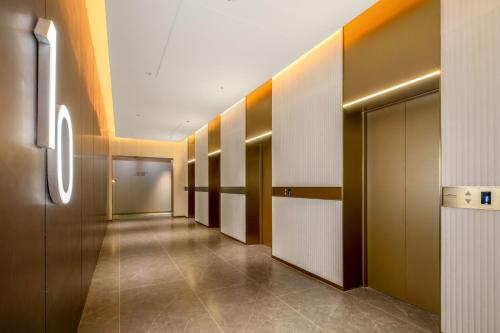 a hallway with a row of lockers in a building at 乌鲁木齐高铁站农业大学万达悦华酒店 in Ürümqi