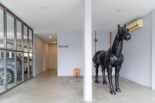 a statue of a horse standing in a hallway at T+ Hotel Butterworth in Butterworth