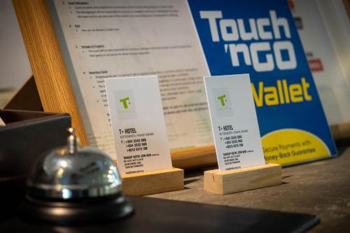 a table with three ticket info signs and a bell at T+ Hotel Butterworth in Butterworth