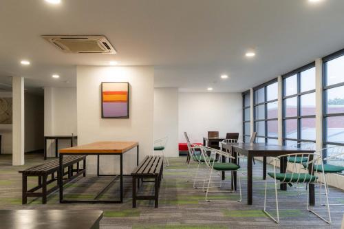 a room with tables and chairs and windows at T+ Hotel Butterworth in Butterworth