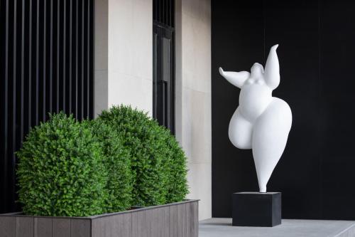 a statue of a rabbit next to a green bush at 乌鲁木齐高铁站农业大学万达悦华酒店 in Ürümqi