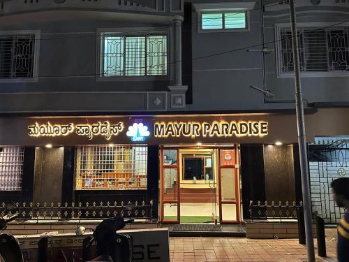 a restaurant with a sign in front of a building at Mayur Paradise in Bangalore