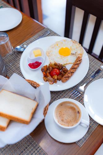 un tavolo con piatti per la colazione e una tazza di caffè di Hotel Romantica a Pokhara