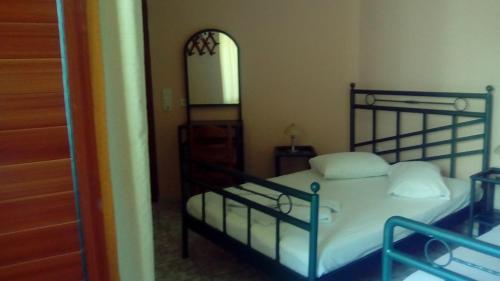 a bedroom with a bed with white sheets and a mirror at Constantinos Studios in Chania