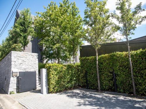 a fence with trees in front of a building at Holiday home in Denee for 21 people in Denée