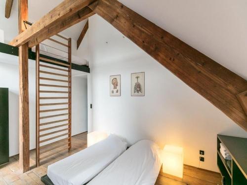 a bedroom with white walls and wooden beams at Holiday home in Denee for 21 people in Denée