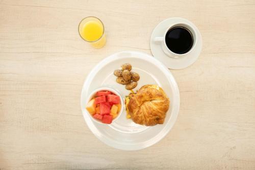 a plate of food with fruit and a cup of coffee at Hotel Jardin De Las Marias in Suchitoto