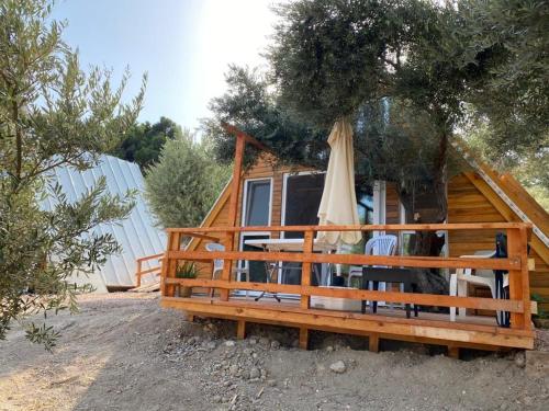 a cabin with an umbrella and chairs in front of it at Bungalow-8 in Karaburun Boyabağ Bay in Karaburun