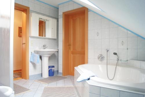 ein Badezimmer mit einer weißen Badewanne und einem Waschbecken in der Unterkunft Annas Ferienwohnung in Rappottenstein