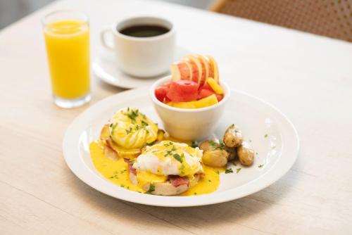 a plate of breakfast food on a table with a cup of orange juice at Hotel Jardin De Las Marias in Suchitoto